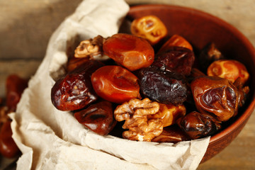 Tasty dates fruits in bowl, on wooden background