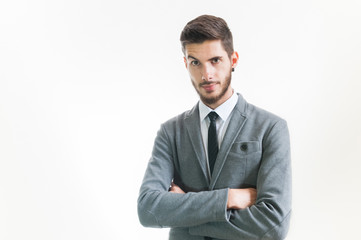 Young serious business man with raised eyebrow and arms crossed 