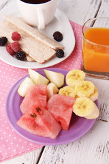 Slices of fruits with crispbreads and glass of juice