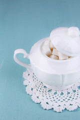 White refined sugar in sugar bowl on color wooden background