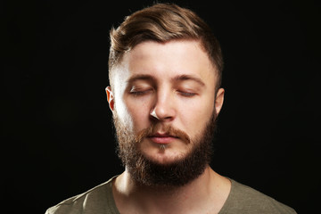 Fototapeta premium Portrait of handsome man with beard on black background
