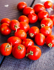 red  tomatoes cherry on dark wooden board,  vertically