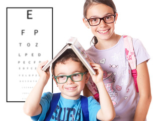Bambini con occhiali e tabella per il controllo della vista