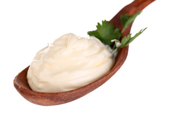 Mayonnaise in wooden spoon isolated on white