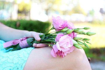 Woman holding beautiful bouquet of eustoma flowers in park