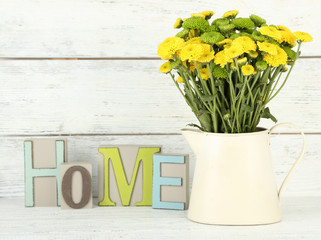 Yellow and green flowers in decorative jug