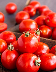 red juicy tomatoes cherry in brown wooden plate