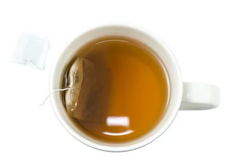 Photo sur Plexiglas Theé Closeup of a cup of tea and teabag viewed from above, isolated