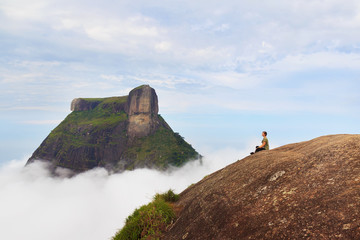 Woman sitting on edge of mountain Pedra Bonita, Rio de Janeiro,