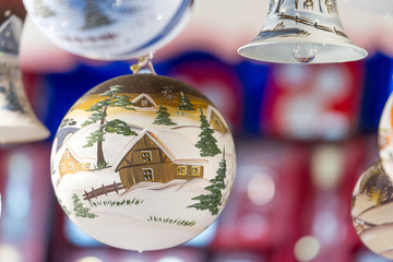 Winter scene with a barn painted on a glass Christmas ornament