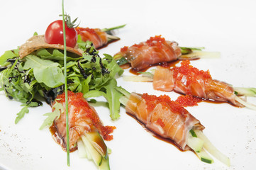 Fish rolls with herbs and fruit on a plate