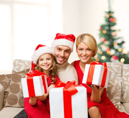 Obraz na płótnie Canvas smiling family giving many gift boxes
