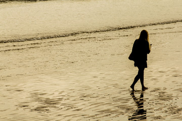 Mujer paseando por la orilla de la playa