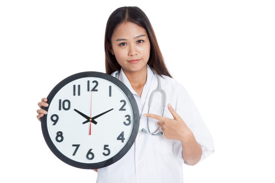 Young Asian female doctor point to a clock