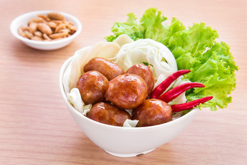 Thai style sausages with fresh vegetables in bowl and peanuts, T