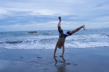 Fototapeta na wymiar Boy to handstand on the beach
