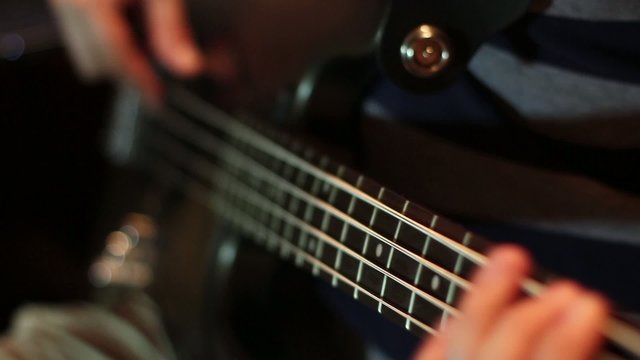 Footage of a musician playing on a bass guitar...