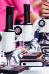 Close-up of a male student using microscope