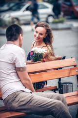 Young couple sitting on bench in street