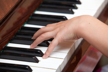 Fototapeta premium Close up of child's hands playing the piano