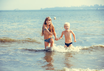 happy little girl and boy in the sea