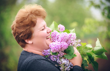 Fototapeta premium woman in park with a big bouquet of a lilac
