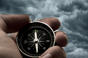 Hand holding black compass