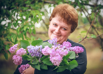 woman in park with a big bouquet of a lilac