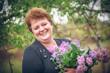 woman in park with a big bouquet of a lilac