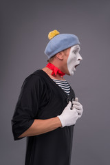 Portrait of male mime in red head and with white face isolated o
