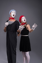 Portrait of funny mime couple with white faces and emotions isol