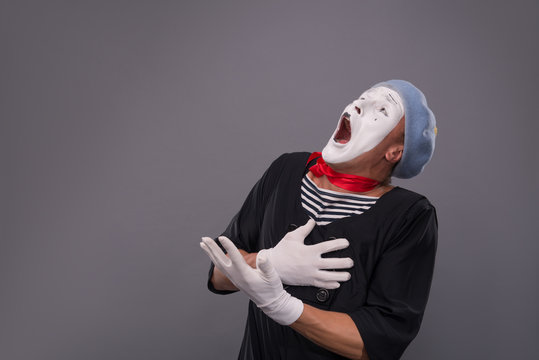 Portrait of male mime in red head and with white face isolated o