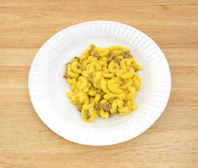 Macaroni and cheese with meat on a paper plate