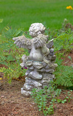 Fototapeta na wymiar Back of a small garden cherubim with wings