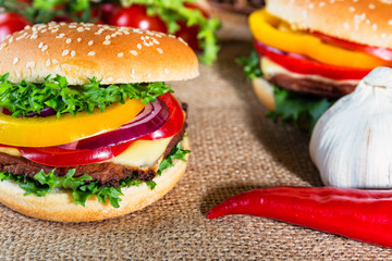 homemade hamburger with fresh vegetables on cutting board