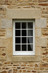 Modernes Kunststofffenster mit Rollladen in Natursteinfassade