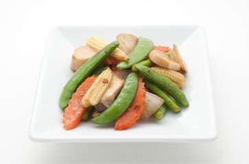 Fried mixed vegetables and pork on white plate