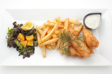 Pieces of chicken fried in batter witn french fries and salad