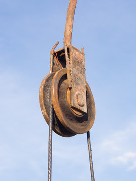 The rusty iron pulley with blue sky background
