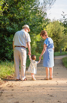 Grandparents and baby grandchild walking outdoors