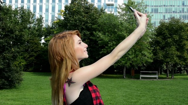 young attractive woman photographs herself (selfie) - nature
