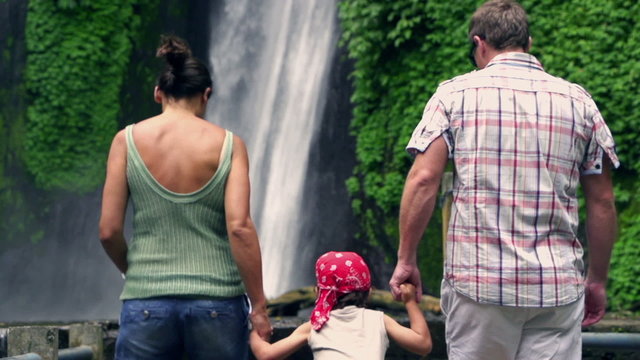 Happy family looking on beautiful waterfall, slow motion 240fps