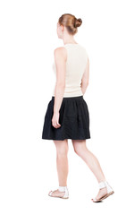 Fototapeta premium back view of walking woman in dress. beautiful blonde girl in m