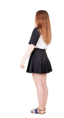 Back view of young redhead woman pointing at wall.