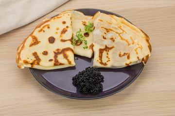 Pancakes with black caviar