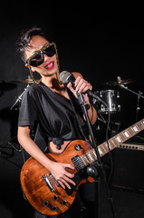 Obraz premium Young woman playing guitar during the concert