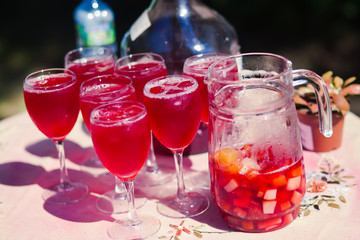 Beautiful line of different coloured cocktails on a open air par
