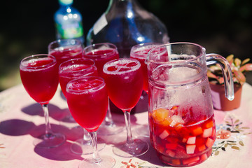 Beautiful line of different coloured cocktails on a open air par