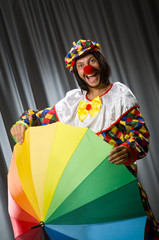 Funny clown with colourful umbrella