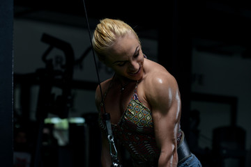 Fototapeta na wymiar Female Bodybuilder Doing Heavy Weight Exercise For Triceps
